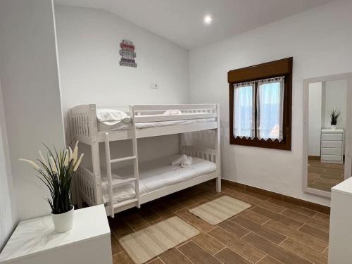 a room with two bunk beds and a mirror at Atico El Lagar de Labastida in Labastida