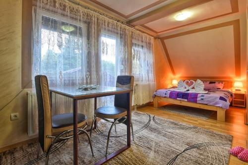 een kamer met een tafel, 2 stoelen en een bed bij Rajski Bor Tara 3 galerija in Kaludjerske Bare