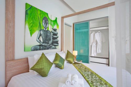 a bedroom with a white bed with green pillows at Sumptuous Modern 3BR Pool Villa Mandala in Ban Saiyuan (1)