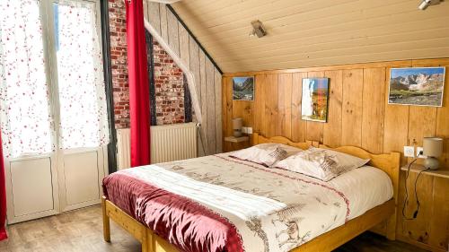 1 dormitorio con 1 cama con cortina roja en Hôtel Le Pas de L'Ours en Cauterets