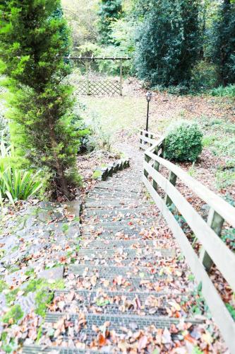 a stone path with a fence in a park at Woodside Oak hot tub & pool sleeps 4-6 in Bideford