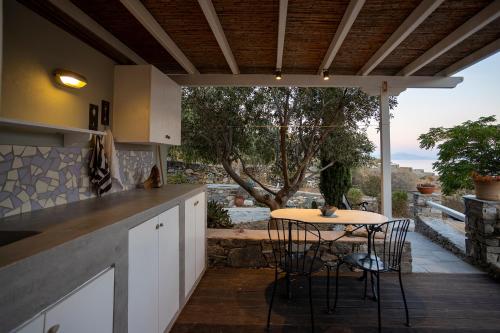 a kitchen with a table and chairs and a patio at Foivos suite at Serifos in Serifos Chora