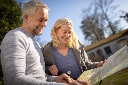 a man and a woman looking at a map at Hotel Ehlers in Schneverdingen