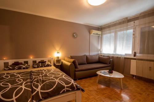 ein Schlafzimmer mit einem Bett und einem Sofa in der Unterkunft Apartmani Barnjak in Zagreb