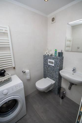 ein Badezimmer mit einer Waschmaschine und einem Waschbecken in der Unterkunft Apartmani Barnjak in Zagreb
