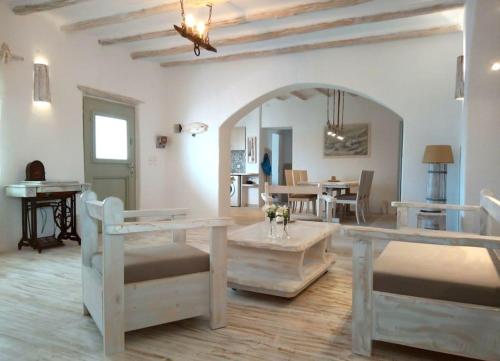 a living room with a table and a dining room at Pebbles Villa with private roof garden in Aliki