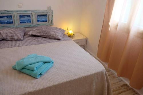 a bedroom with a bed with a blue towel on it at Pebbles Villa with private roof garden in Aliki