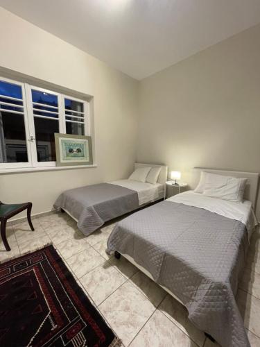 a bedroom with two beds and a window at 74 Volos in Volos