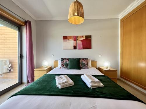 a bedroom with a large bed with two towels on it at Albufeira Garden Villa With Pool by Homing in Albufeira