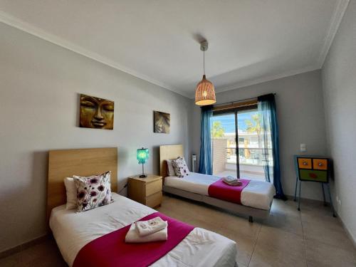 a bedroom with two beds and a window at Albufeira Garden Villa With Pool by Homing in Albufeira