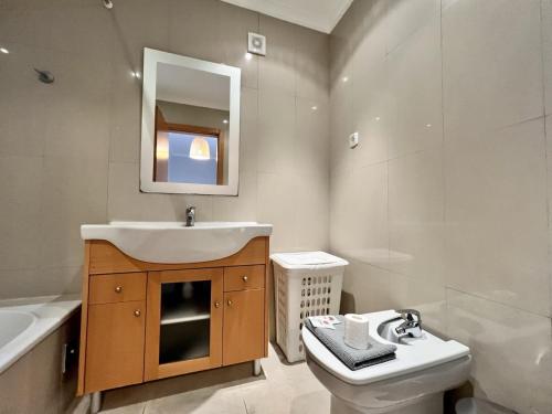 a bathroom with a sink and a toilet and a mirror at Albufeira Garden Villa With Pool by Homing in Albufeira