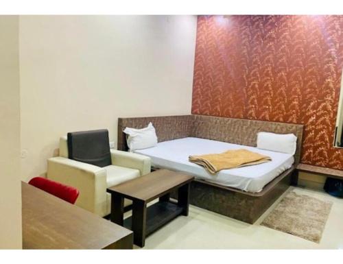 Habitación pequeña con cama y silla en Hotel Mohan Palace, Kondagaon en Kondegaon