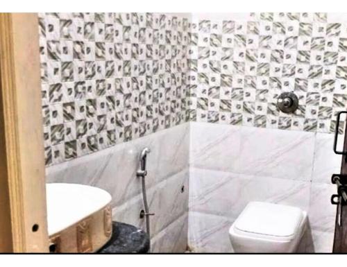 y baño con aseo blanco y lavamanos. en Hotel Mohan Palace, Kondagaon en Kondegaon