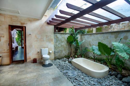 uma casa de banho com banheira e WC em Aryaswara Villa Ubud em Ubud
