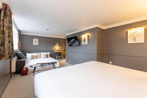 a hotel room with a bed and a couch at The Goodenough Hotel London in London