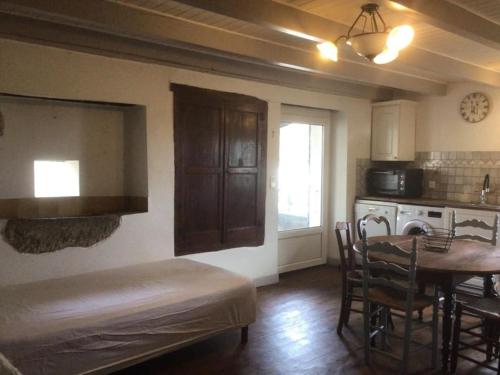 une cuisine avec une table et une salle à manger dans l'établissement jolie maison de caractère proche de Castres, à Burlats