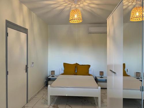 a bedroom with a white bed and two lamps at ALLAMANDA DES BOIS in Deshaies