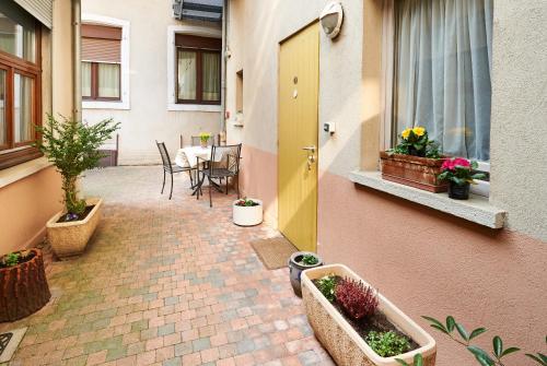 a patio with a table and a yellow door and plants at Hôtel De L'Ill in Strasbourg
