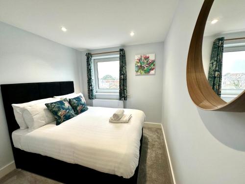 a bedroom with a large bed with a mirror at Stunning Sea View Two Bed Apartment - With Balcony in Bournemouth