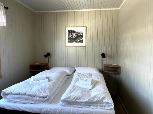 En eller flere senger på et rom på Olenilsøy Cabins