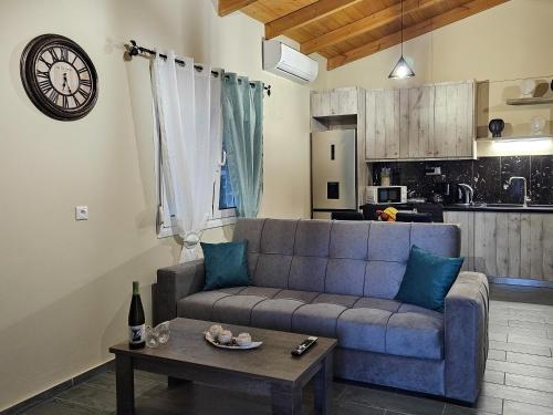 ein Wohnzimmer mit einem blauen Sofa und einem Tisch in der Unterkunft Elia Paradise Villa with Pool in Iraklio