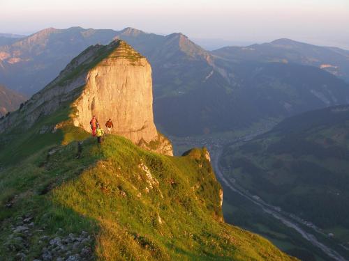 two people standing on top of a mountain at Hotel Kanisfluh in Mellau