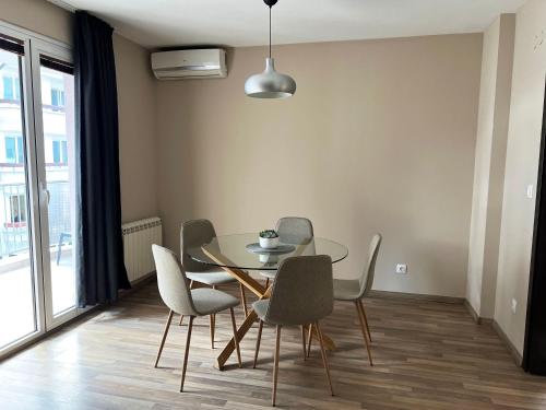 a dining room with a glass table and chairs at Lubata 5 Apartments - 2 bedrooms in Sofia