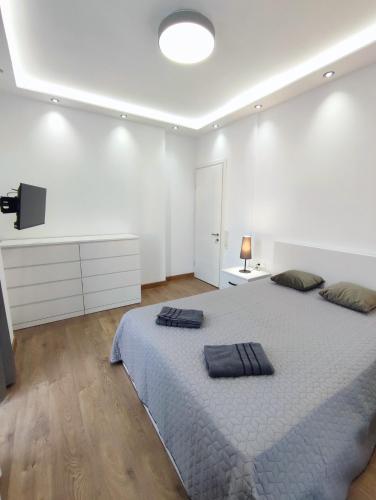 a white bedroom with a large bed and a television at European Village Old Villa 6 in Gonio