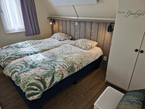 1 dormitorio con cama con edredón en Gezellig vakantiehuis 't Gramsbergje, en Gramsbergen