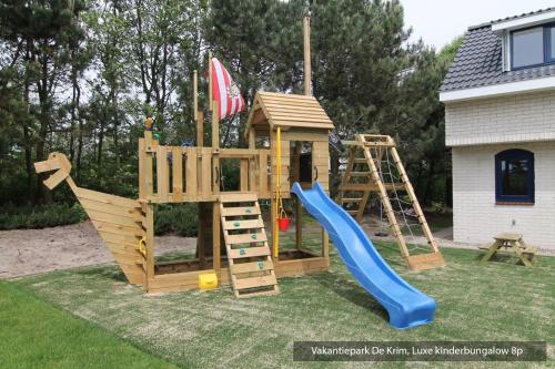 a wooden playset with a slide and a slideintend at Vakantiepark De Krim Texel in De Cocksdorp