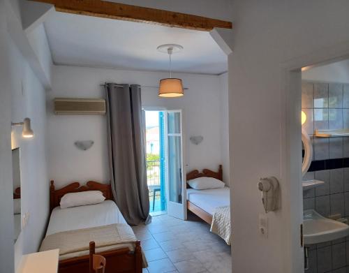 a bedroom with two beds and a bathroom with a tub at Villa Margarita in Spetses