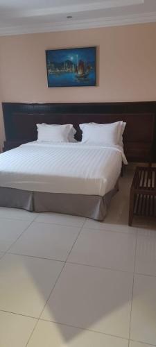a bedroom with a large bed with white sheets and pillows at Taleen Hettin in Riyadh