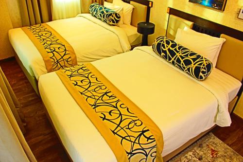 Seef Villas في المنامة: سريرين في غرفة الفندق صفراء وبيضاء