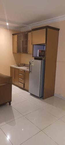 a kitchen with a refrigerator and a couch in a room at Taleen Hettin in Riyadh