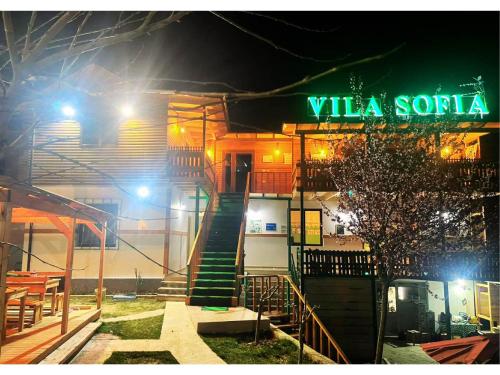Memaliaj的住宿－Vila Sofia Gllava - Resort，一座建筑,上面有夜间读vla santa的标志