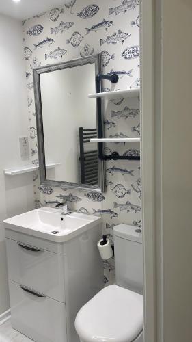 ein Badezimmer mit einem WC, einem Waschbecken und einem Spiegel in der Unterkunft Thistle House Guest House in Saint Catherines