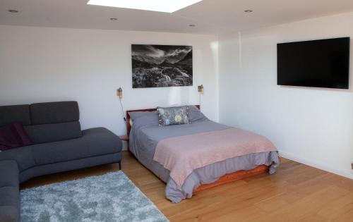 1 dormitorio con cama, sofá y TV en Whashton Studio en Richmond