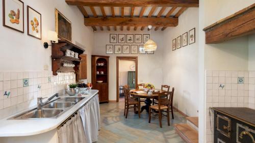 cocina con fregadero y mesa con sillas en Cosciano 12, Emma Villas, en Pomarance