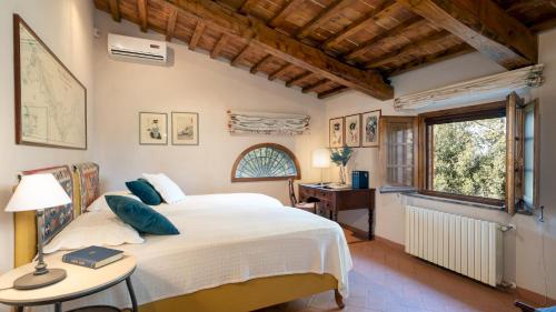 1 dormitorio con cama, escritorio y ventana en Cosciano 12, Emma Villas, en Pomarance