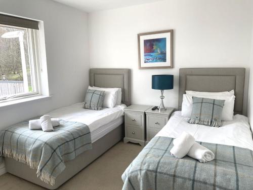 a bedroom with two beds and a window at Millwood in Aviemore