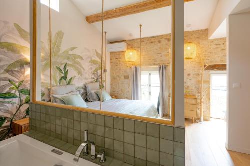 a bathroom with a large mirror over a sink at Songes de vigne in Bagnols