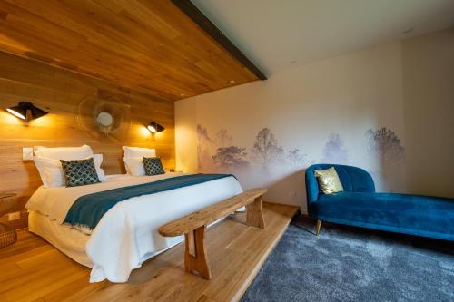 um quarto com uma cama e um sofá azul em Songes de vigne em Bagnols