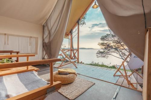 a room with a view of the ocean from a tent at Obonjan Island Resort in Šibenik