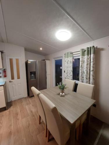 a kitchen with a dining room table with chairs at Drumrammer Farm Lodge in Ahoghill