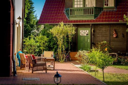 a house with a green door and a table and chairs at Matys Landhausperle an der Müritz in Röbel