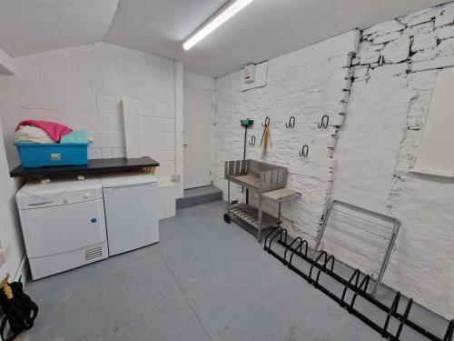 eine Küche mit weißen Wänden, einer Theke und einem Waschbecken in der Unterkunft Lewis Gethin House, Newly renovated cottage sleeps 9, close to bike park wales in Merthyr Tydfil