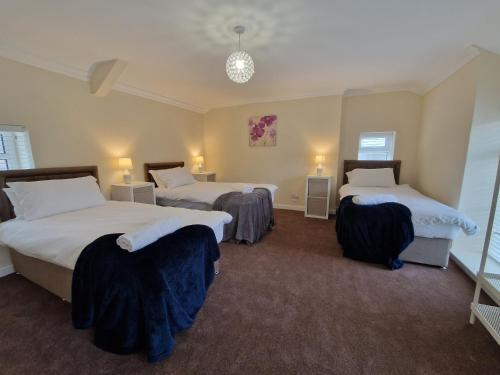 1 dormitorio con 2 camas y 2 sillas en Lewis Gethin House, Newly renovated cottage sleeps 9, close to bike park wales, en Merthyr Tydfil