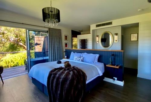 a bedroom with a large bed and a large window at Amaroo Valley Springs in Barrengarry
