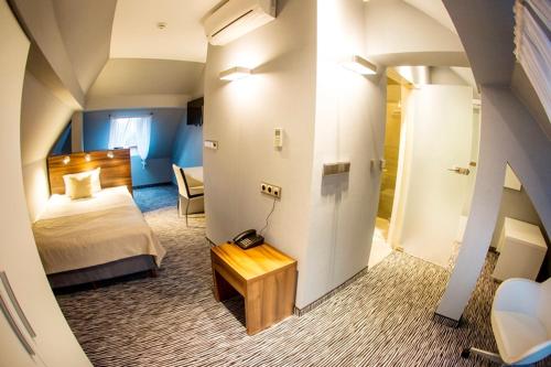 ein Hotelzimmer mit einem Bett und einem Tisch in einem Zimmer in der Unterkunft Hotel Gorczowski Katowice Chorzów in Chorzów