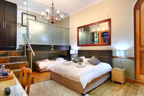 a bedroom with two beds and a mirror at Wilton Manor in Cape Town